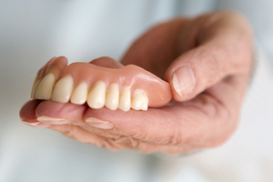 A person holding a top denture