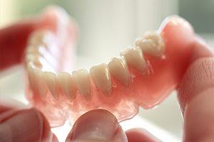 Hands holding full dentures