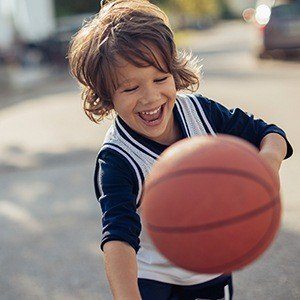 Smiling little boy playing basketball