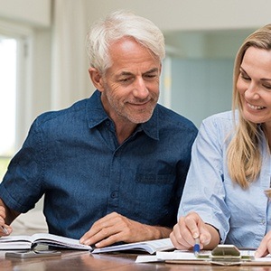 Older man and woman reviewing dental insurance paperwork