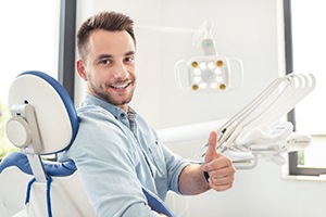 Male dental patient giving thumbs up after root canal therapy in Carrolton, TX