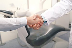 Dentist and patient shaking hands after root canal therapy in Carrolton, TX