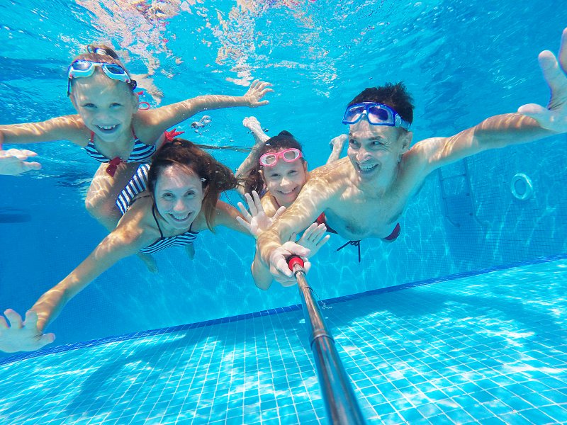 Patient with good dental health swimming with family