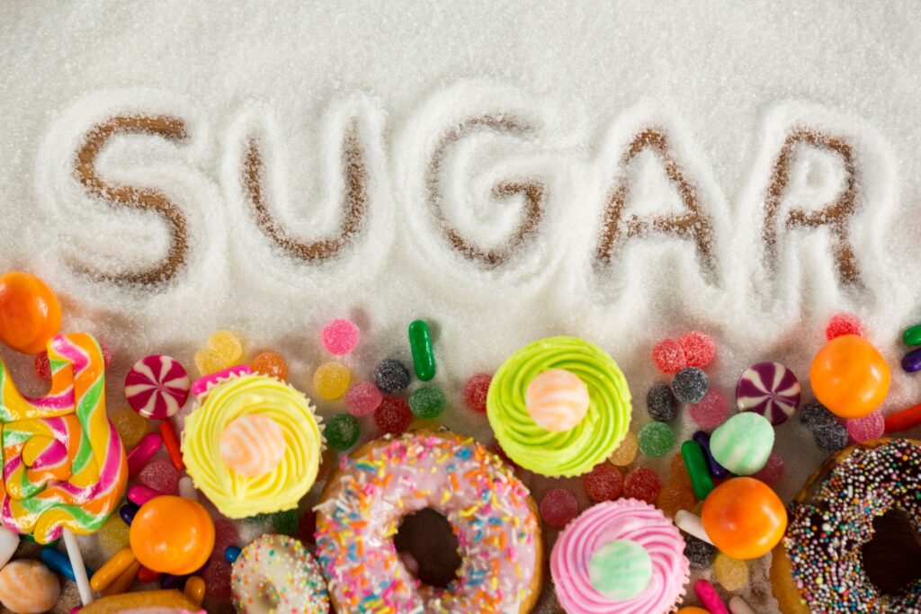 Sugary foods below a pile of white powder with "sugar" written in it